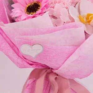 Detailansicht eines rosa Seifenblumenstraußes mit künstlichen Orchideen und Herzanhänger