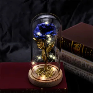 Detail of glowing blue gold foil rose in glass dome with LED lights