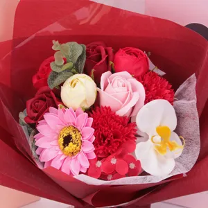 Detailansicht eines Seifenblumenstraußes mit Rosen und Orchideen in rotem Geschenkpapier