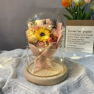 Detailopname van de romantische glazen koepel met zonnebloem en warme LED verlichting.