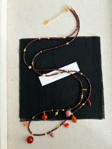 Detaillierte Makroansicht der Granat-Perlenkette mit bunten Edelsteinanhängern.