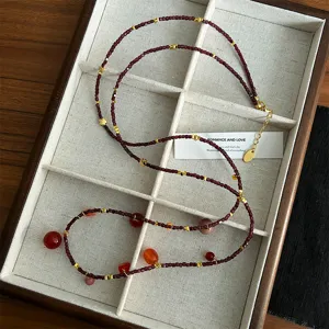 Detailansicht einer Vintage-Granatperlenkette mit Goldakzenten in einem Display.