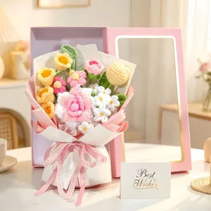 Detailansicht des handgearbeiteten Häkelblumenstraußes mit bunten Rosen und Lilien im Geschenk.