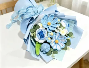 A detailed view of a handmade blue crochet flower bouquet with elegant wrapping paper