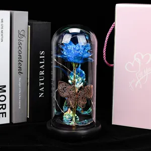 Vue détaillée de la rose éternelle sous dôme en verre avec fleur bleue, papillon et lumières LED.