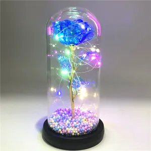 Detailansicht einer ewigen blauen Rose in einer Glaskuppel mit bunten LED-Lichterketten Dekoration