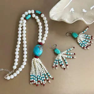 Close-up of Tibetan style beaded necklace and turquoise tassel earrings jewelry set