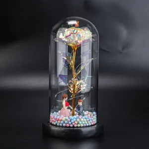 Detailansicht der ewigen Goldrose im Glasdom mit LED-Lichterkette und kleinen Paarfiguren.