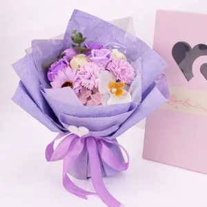 Detailansicht eines lila Seifenblumenstraußes mit Rosen und Orchideen in Geschenkbox