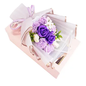 Detailed view of artificial soap rose and carnation flower bouquet in elegant pink gift box.