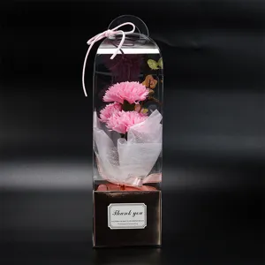 Vue rapprochée détaillée du bouquet de fleurs de savon œillet rose en boîte transparente.