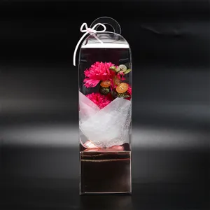 Détail du magnifique bouquet de fleurs de savon œillet artificiel dans une boîte cadeau transparente.