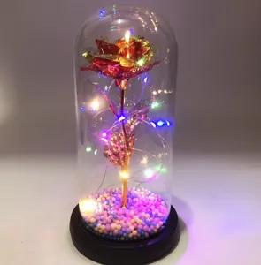 Detailansicht der künstlichen Goldfolienrose in Glaskuppel mit bunten LED-Lichtern