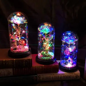 Wunderschöne Galaxie-Rose im Glasdom mit bunten LED-Lichtern und romantischen Figuren