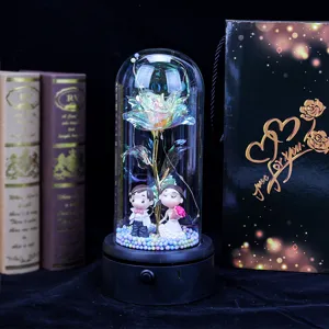 Close-up of galaxy rose in glass dome with bride and groom figurines and gift bag