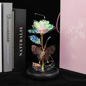 Details de la rose d'or coloree et du papillon ornement luminescent LED socle noir.