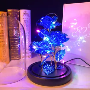 Primer plano detallado de rosas azules brillantes con luces LED en cúpula de vidrio