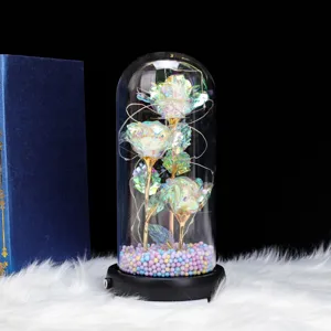 Detailed close-up view of the glowing iridescent foil rose glass dome with colorful beads base.