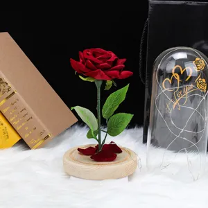 Rosa de terciopelo rojo en cúpula de vidrio con luces LED cálidas y base de madera