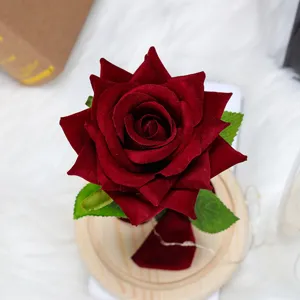 Detalle de una rosa artificial de terciopelo rojo con luces LED en base de madera para regalo.