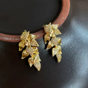 Detalle de pendientes vintage franceses con forma de hoja dorada y microdiamantes brillantes