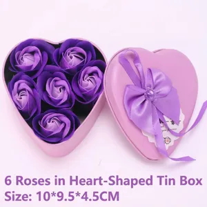 Primer plano de caja metálica de corazón con seis rosas de jabón púrpuras y lazo