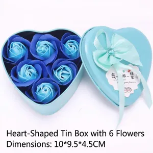 Detalle macro de una caja de metal azul en forma de corazón con seis rosas de jabón.