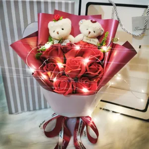 Detailansicht eines roten Seifenrosenstraußes mit Teddybären und warmen LED-Lichtern