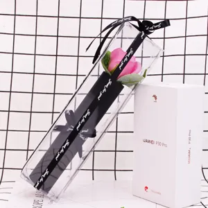 Close-up of a single pink soap rose flower in a clear PVC box for Valentine's Day