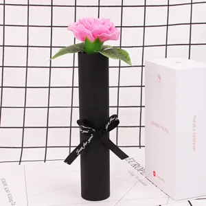 Close-up detail of a pink carnation soap flower in an elegant black cylinder gift box