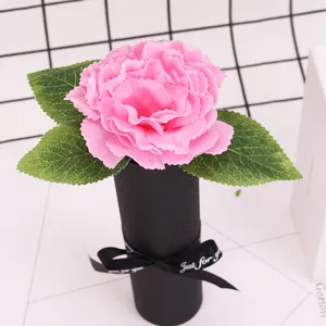 Close-up of a pink soap carnation flower in a black gift box with ribbon
