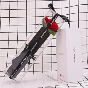 Close-up detail of a single red soap rose packaged in a clear PVC gift box with ribbon