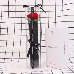 Detail view of a single red soap flower in a PVC box next to a phone box for scale