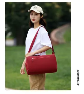 Vue lifestyle extérieur d'un grand sac de voyage fitness rouge porté par une femme