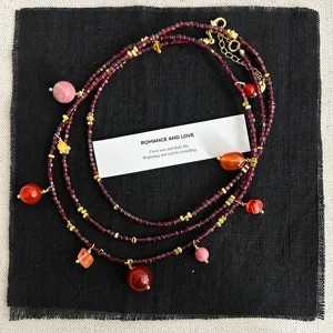 Detailansicht einer Vintage-Granat-Perlenkette mit roten Steinanhängern auf schwarzem Leinen