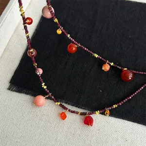Detailansicht einer Vintage-Granatperlenkette mit bunten Steinanhängern und Goldakzenten