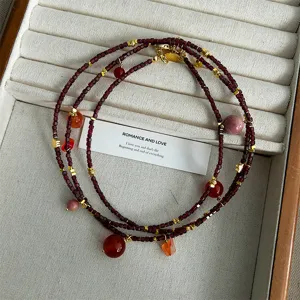 Detailansicht einer böhmischen Granat-Perlenkette mit Goldakzenten und Naturstein-Anhängern