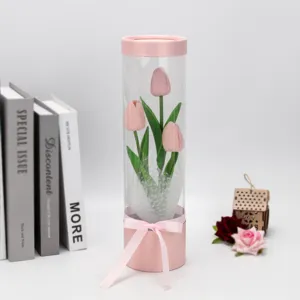 Transparent cylindrical gift box featuring pink artificial tulips for home decoration.