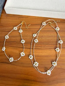 Detail of elegant pearl flower necklace set including choker and long sweater chain.
