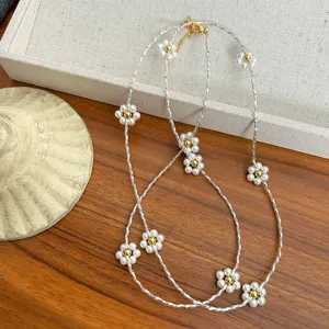 Detailed view of flower pearl necklace with silver twisted chain and gold accents