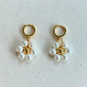 Detailed view of handmade pearl flower dangle earrings with gold hoops and golden bead core