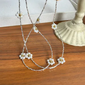 Close-up of elegant white pearl flower pendant on a silver-toned textured chain