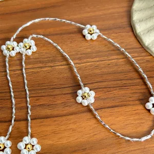 Detailed view of handcrafted silver tubular beaded necklace with pearl flower accents
