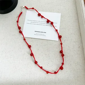 Hand-woven red rope necklace featuring vibrant red agate beads on an elegant background