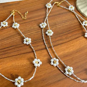 Detail view of an elegant pearl flower necklace with silver chain and gold accents.