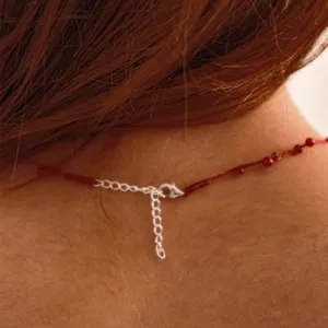 Handwoven red string necklace featuring red agate beads and adjustable silver lobster clasp
