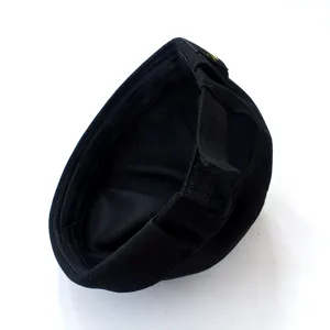 Detail der schwarzen Docker Mütze mit verstellbarem Riemen und Stoffetikett, Streetwear.