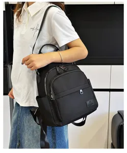 Casual black nylon backpack for students, stylish daily school bag with multiple zip pockets.