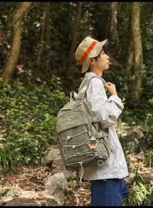 Olive green large capacity backpack for students shown in an outdoor forest setting
