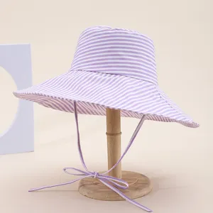 Purple white striped wide brim bucket hat detail, stylish sun protection beach summer hat.
